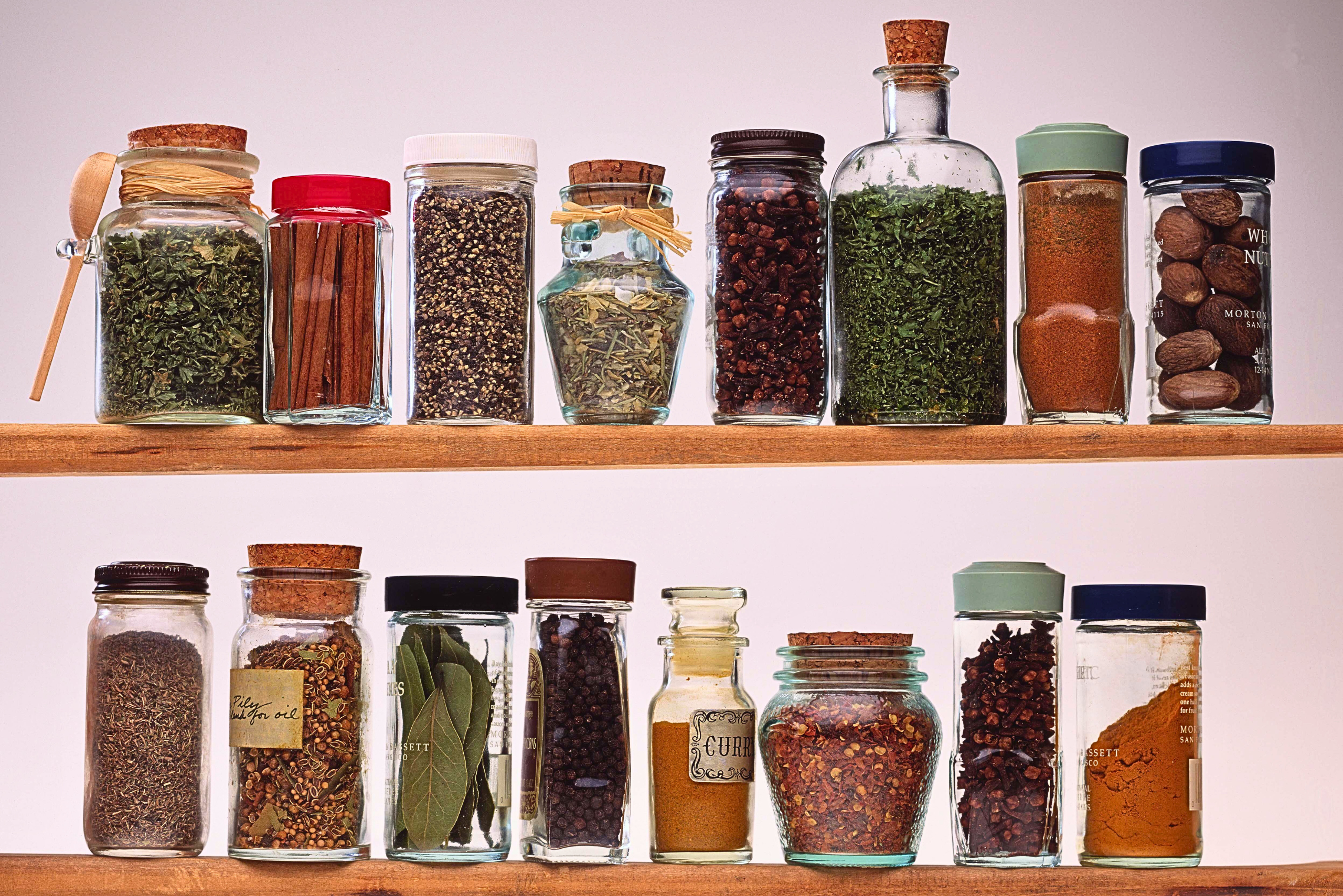 Rack with jar bottles holding essential spices for cooking