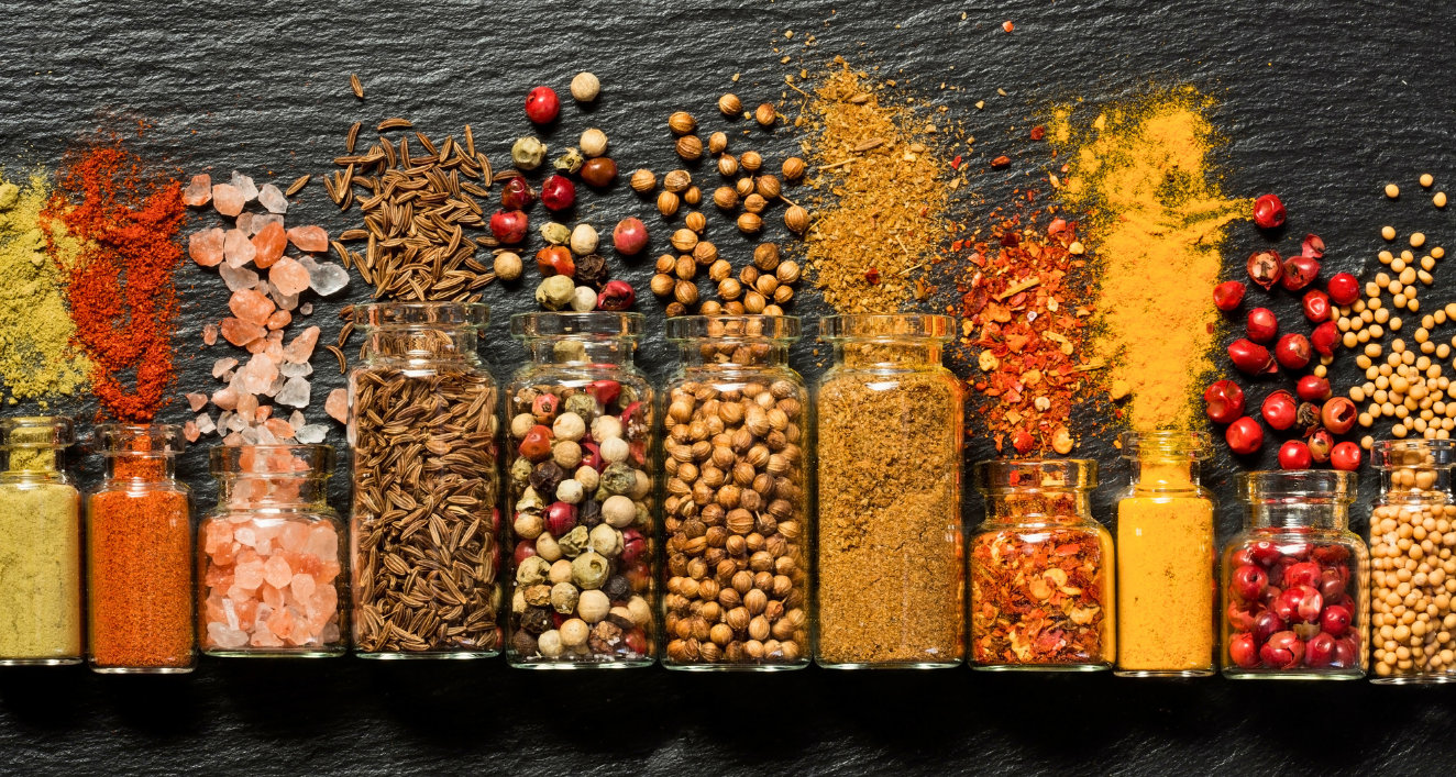 Essential spices for cooking: a vibrant arrangement of colorful spices in glass jars.